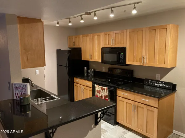 a kitchen with granite countertop a stove and a refrigerator