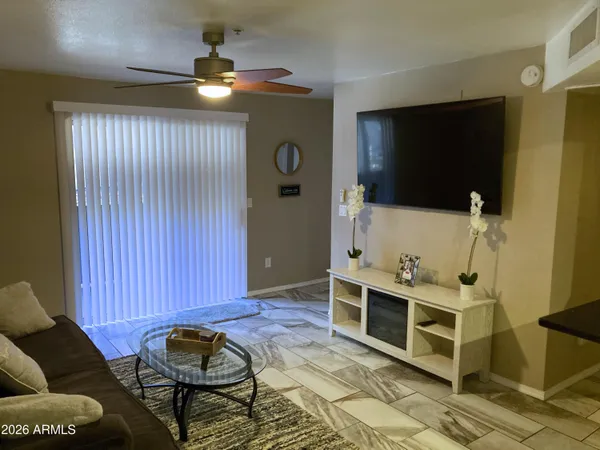 a living room with furniture a flat screen tv and gym equipment