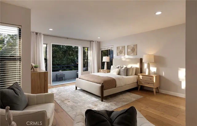 a bedroom with a balcony a bed and dresser with wooden floor