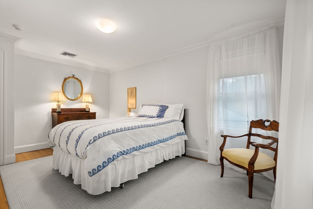 134 Dedham Street Dover, MA 02030 - Photo 26 of 42 a spacious bedroom with a bed and chair