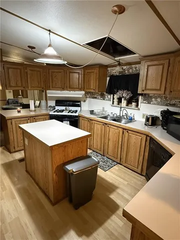a kitchen with wooden cabinets a sink and stainless steel appliances