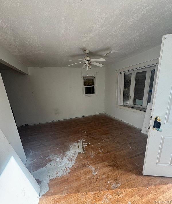 20 North Somerset Road Amityville, NY 11701 - Photo 5 of 5 Spare room featuring wood-type flooring, a ceiling fan, and a textured ceiling