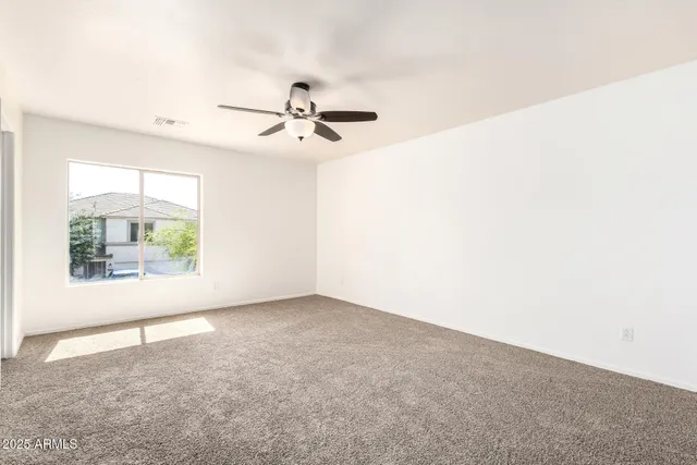 an empty room with a window and a ceiling fan