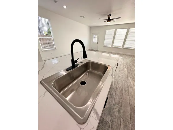 a kitchen with granite countertop a sink and cabinets