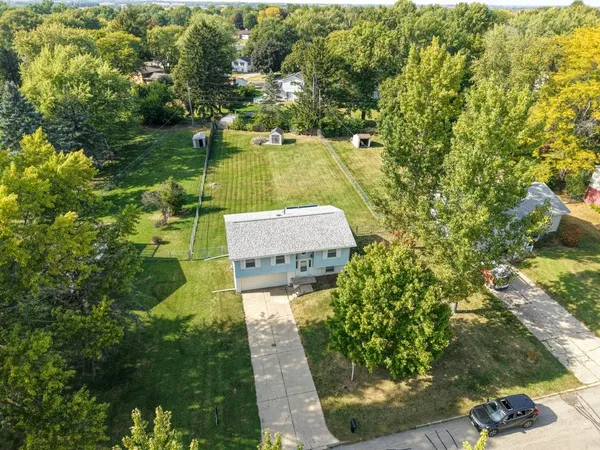 an aerial view of a house with a yard basket ball court and outdoor seating