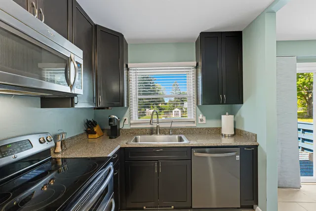 a kitchen with stainless steel appliances a sink stove and cabinets