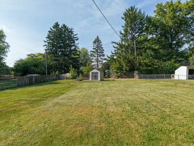a front view of a house with a yard and trees