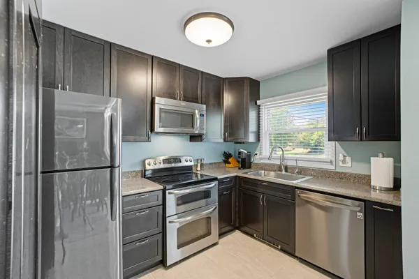 a kitchen with stainless steel appliances granite countertop a sink stove and refrigerator