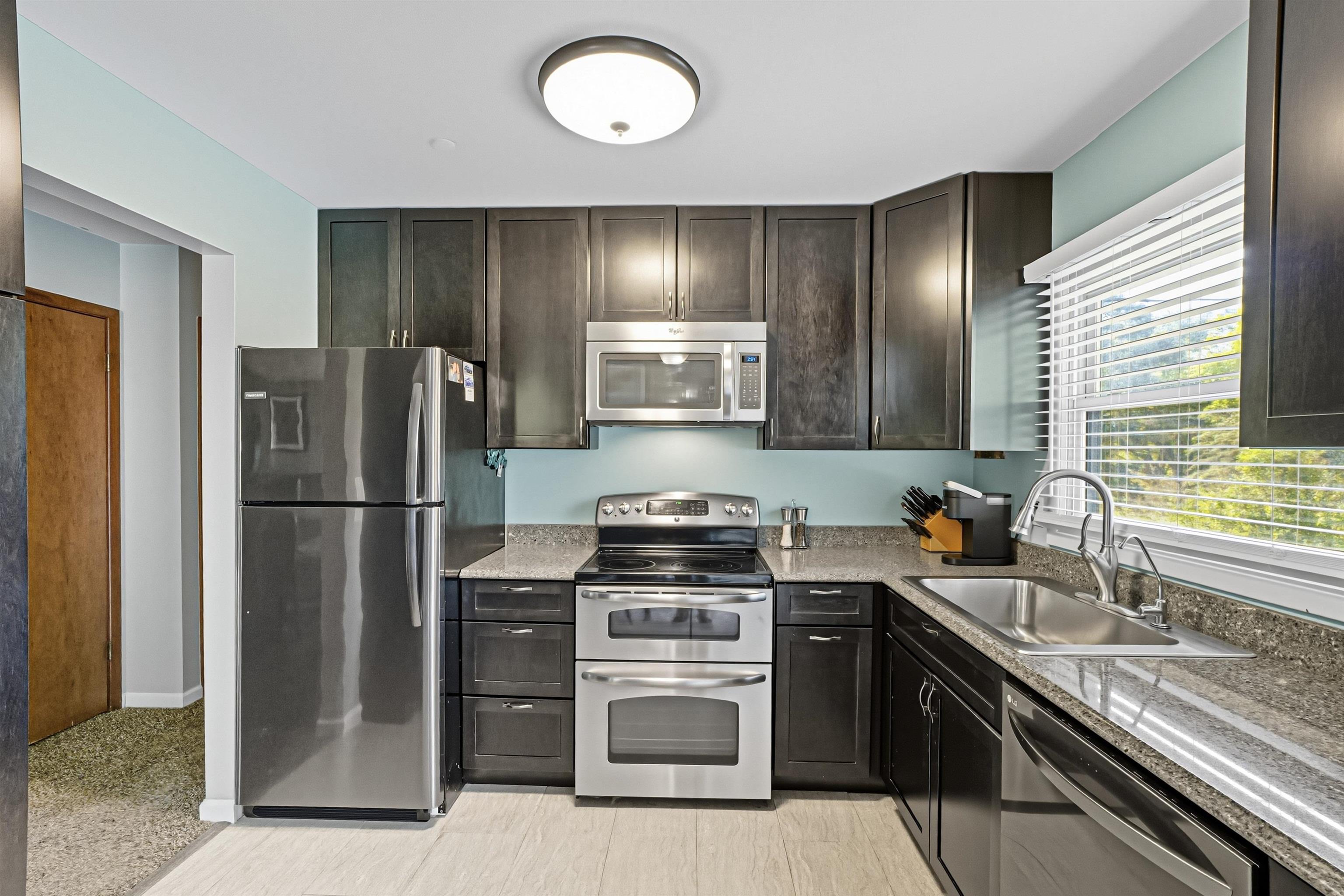 2124 West Middlebury Road Freeport, IL 61032 - Photo 6 of 23 a kitchen with a refrigerator sink and wooden cabinets