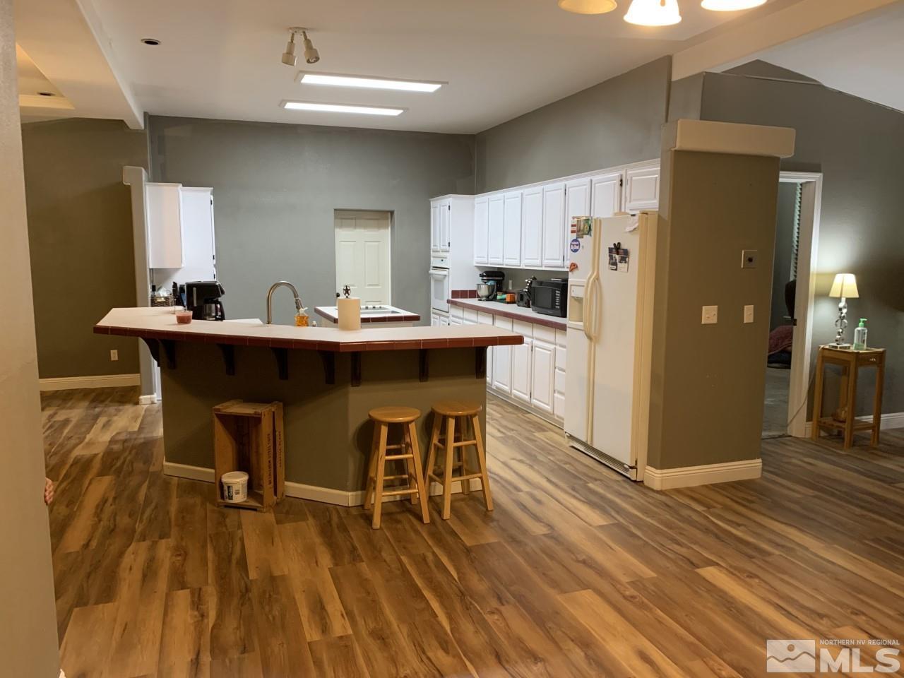 450 Reservoir Road Lovelock, NV 89419 - Photo 9 of 37 a dining room with kitchen island stainless steel appliances a table chairs refrigerator and sink