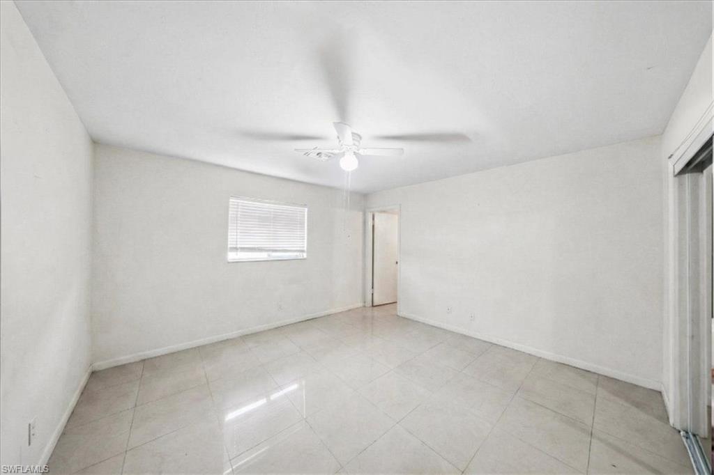 4438 Pine Lake Road Bonita Springs, FL 34134 - Photo 13 of 33 an empty room with a ceiling fan and a window