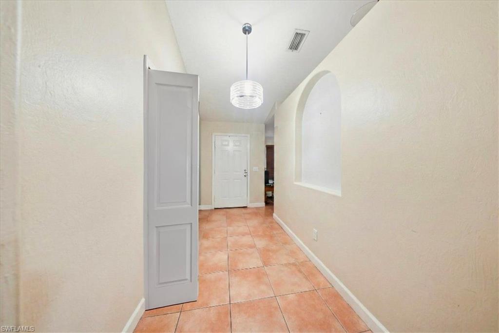 4438 Pine Lake Road Bonita Springs, FL 34134 - Photo 16 of 33 a view of an empty room with wooden floor and windows