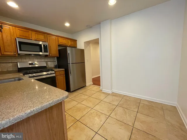 a kitchen with stainless steel appliances a refrigerator and a stove top oven
