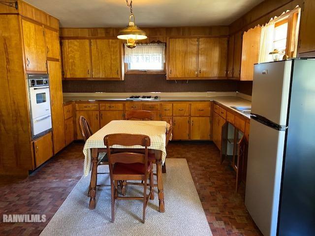 6389 C Riverview Road Thomson, IL 61285 - Photo 12 of 16 a kitchen with stainless steel appliances granite countertop a refrigerator a stove a sink a dining table and chairs with wooden floor
