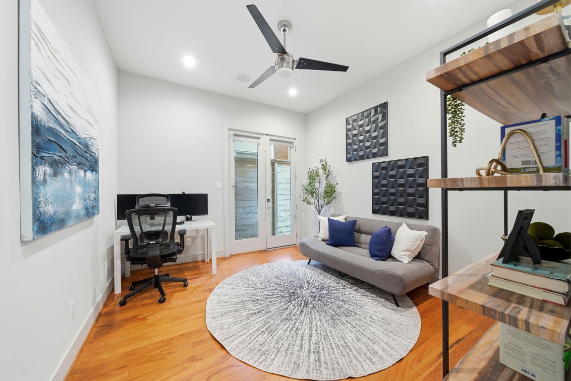 1405 Vermont Street, Unit A Houston, TX 77006 - Photo 23 of 46 Ideal for a guest suite or a quiet home office, this first-floor bedroom features polished hardwood floors and a contemporary feature accent wall. French doors provide private access to a low-maintenance outdoor area, while the spacious layout comfortably accommodates a seating zone and a dedicated workspace. Sleek designer finishes, including a modern ceiling fan and recessed LED lighting, enhance the sophisticated atmosphere of this versatile sanctuary.