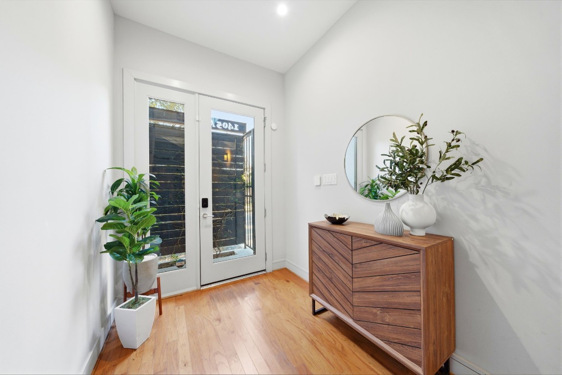 1405 Vermont Street, Unit A Houston, TX 77006 - Photo 9 of 46 Polished hardwoods and soaring ceilings create a dramatic first impression in this light-filled entry, where a modern floating staircase serves as a striking architectural centerpiece. Accent lighting and designer finishes lead the way through the hallway, which provides a seamless connection to the first-floor guest suite and private elevator-ready spaces.