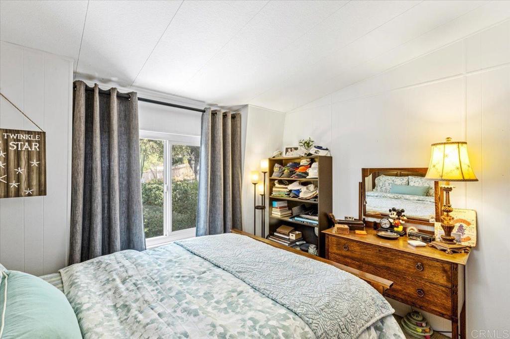 18218 Paradise Mountain Road, Unit 116 Valley Center, CA 92082 - Photo 18 of 35 a bedroom with a bed and a dresser in it