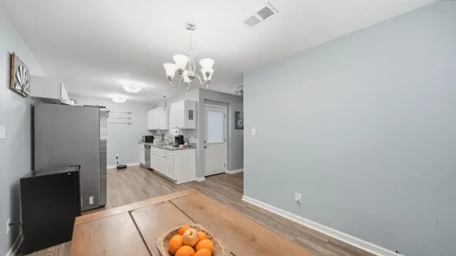 a view of a kitchen with a sink dishwasher a refrigerator and wooden floor