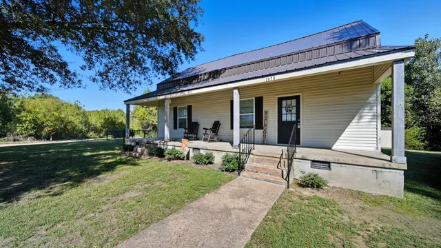 a view of a house with backyard and sitting area
