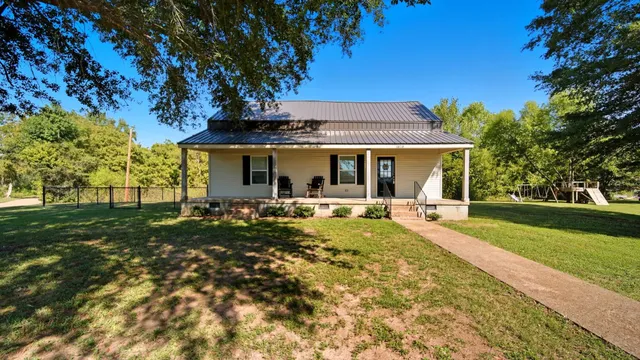 a view of backyard of house with green space
