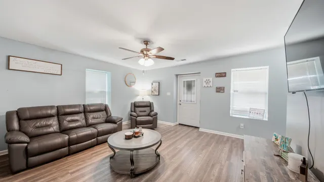 a living room with furniture and wooden floor