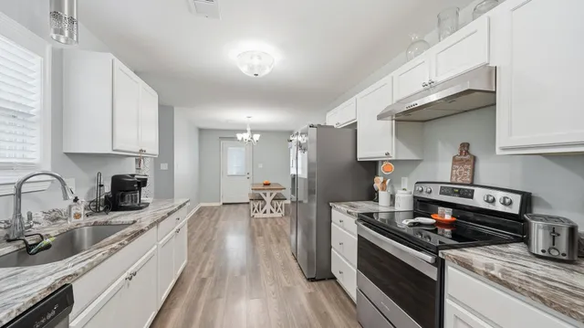 a kitchen with stainless steel appliances a sink stove and cabinets