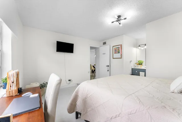 a bedroom with a bed and a flat screen tv