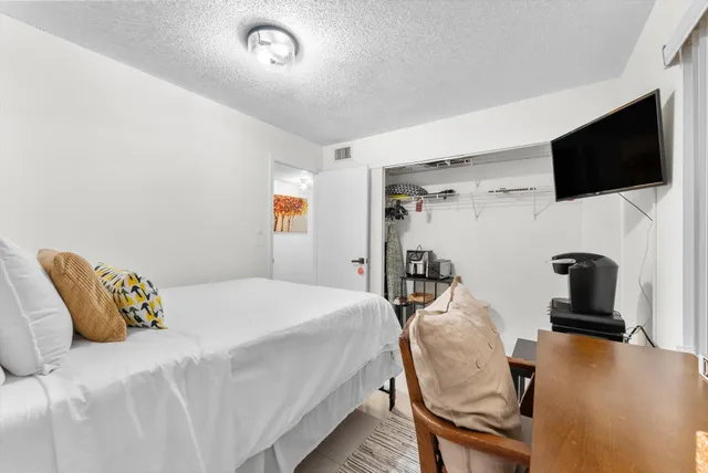 a bedroom with a bed and a flat screen tv