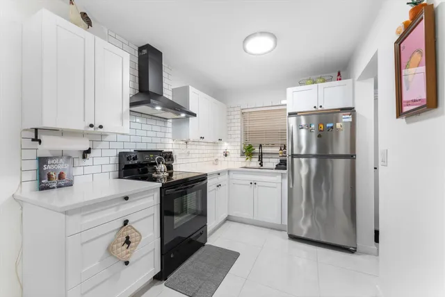 a kitchen with stainless steel appliances granite countertop a refrigerator sink and stove