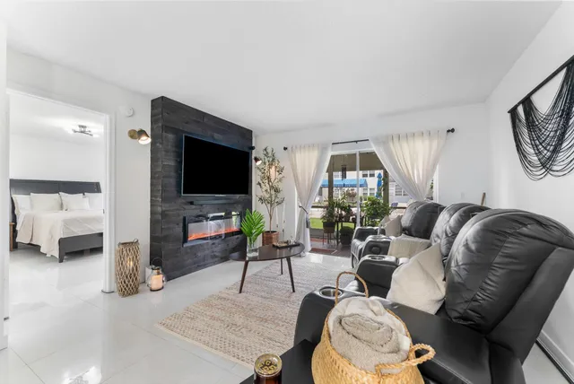 a living room with furniture a window and a flat screen tv