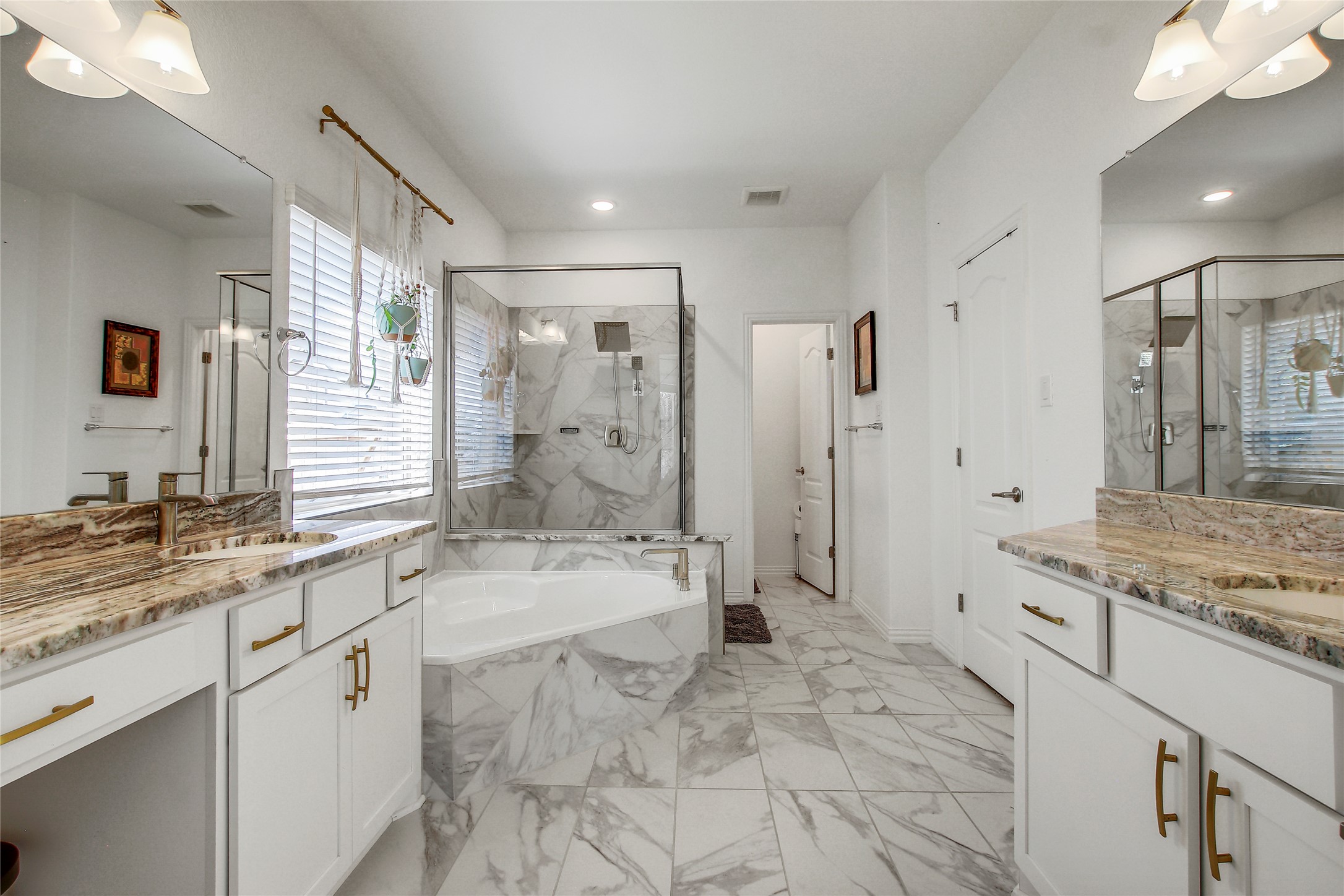 104 Millbend Road Georgetown, TX 78633 - Photo 21 of 40 A lavish primary bathroom provides a spacious soaking tub, a sleek glass shower, and elegant granite vanity tops.