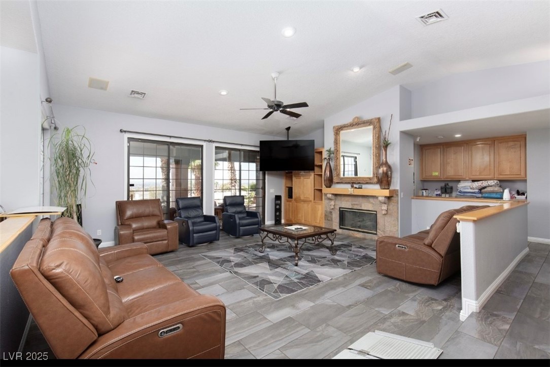 440 Probst Way Las Vegas, NV 89110 - Photo 18 of 42 Living room featuring a stone fireplace, lofted ceiling, ceiling fan, and recessed lighting