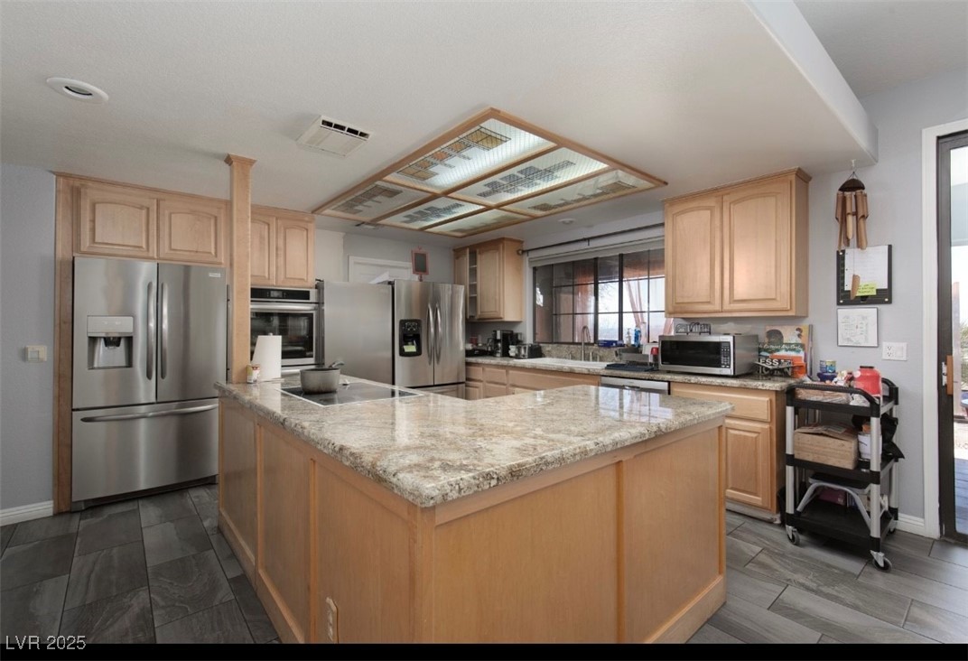 440 Probst Way Las Vegas, NV 89110 - Photo 20 of 42 Kitchen with stainless steel appliances, light brown cabinetry, a center island, and light stone counters