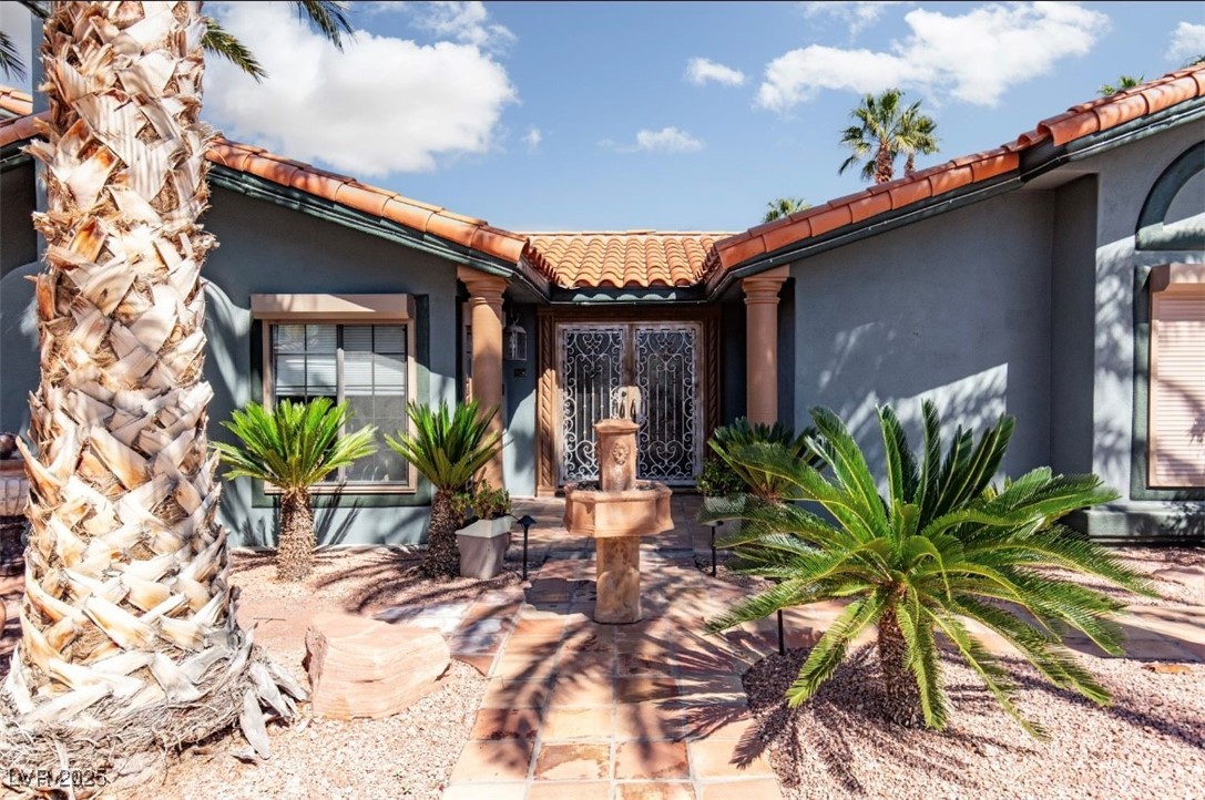 440 Probst Way Las Vegas, NV 89110 - Photo 3 of 42 Property entrance featuring a tiled roof and stucco siding