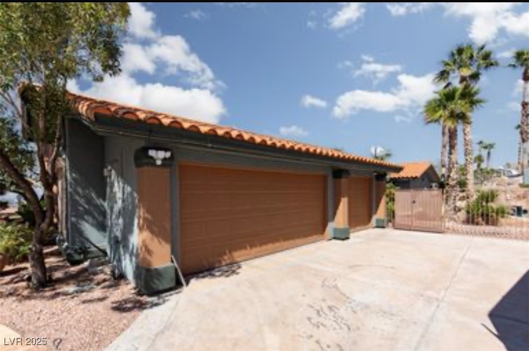 440 Probst Way Las Vegas, NV 89110 - Photo 35 of 42 View of front of home featuring a tile roof, a garage, an outbuilding, stucco siding, and concrete driveway
