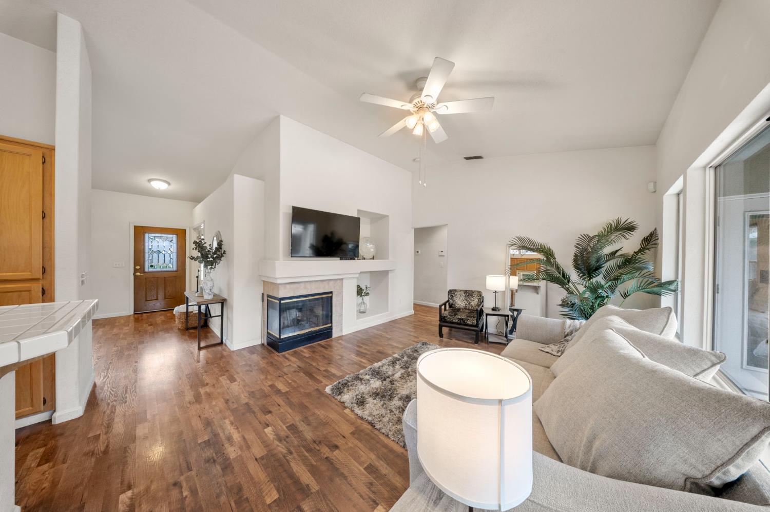 255 Osborne Court Ripon, CA 95366 - Photo 8 of 34 a living room with furniture a fireplace and a flat screen tv