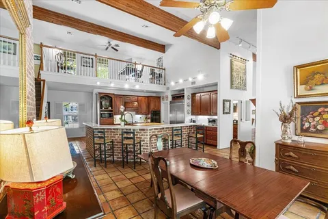 a living room with stainless steel appliances furniture a dining table and kitchen view