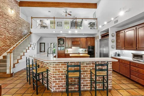 a kitchen with stainless steel appliances granite countertop a sink and a refrigerator