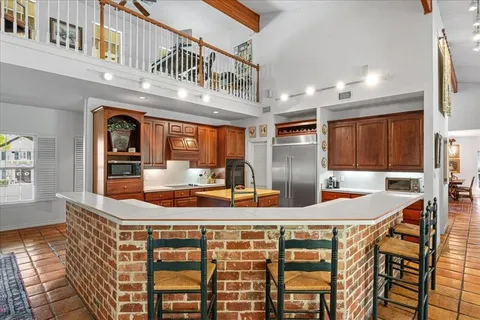 a kitchen with stainless steel appliances kitchen island granite countertop a refrigerator and microwave
