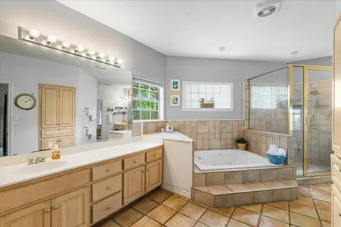 a spacious bathroom with a double vanity sink a mirror and a bathtub