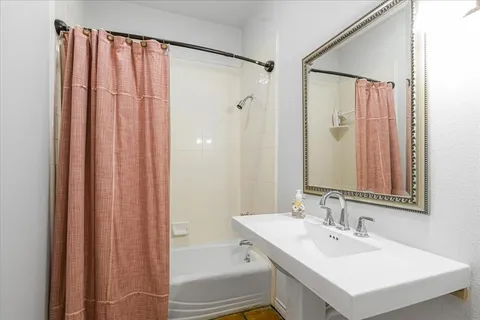 a bathroom with a bathtub a sink and a mirror