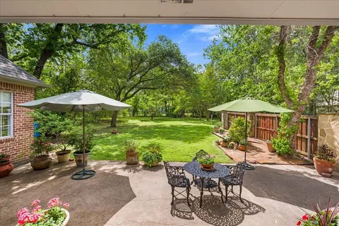 a view of a patio with furniture and table under an umbrella