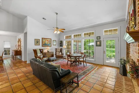 a living room with furniture a dining table and a floor to ceiling window