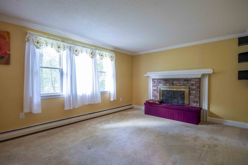 9 Elwood Road Derry, NH 03038 - Photo 28 of 42 a living room with fireplace and a large window