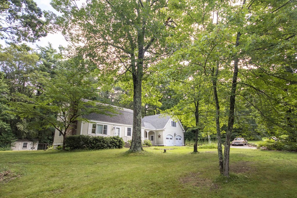 9 Elwood Road Derry, NH 03038 - Photo 3 of 42 a front view of a house with a garden and trees