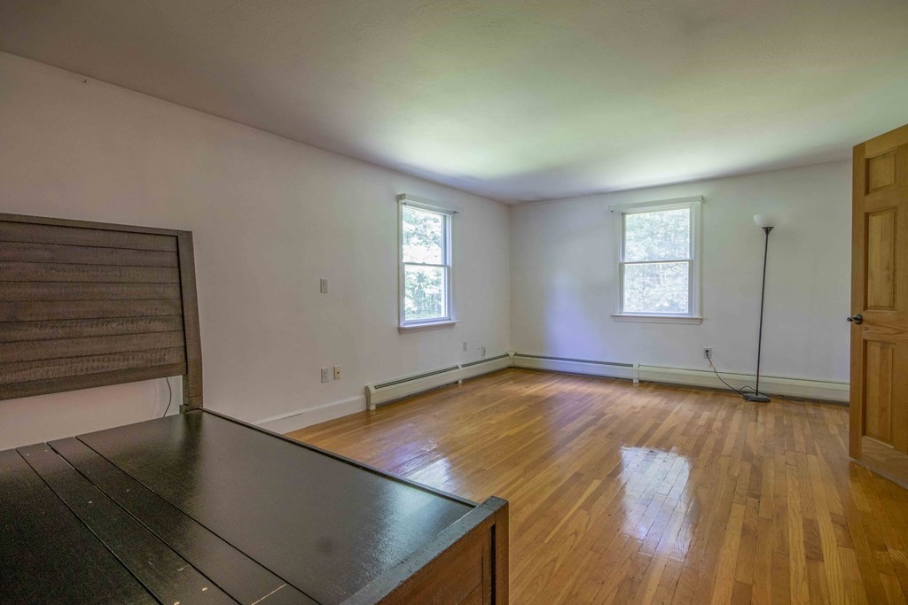 9 Elwood Road Derry, NH 03038 - Photo 34 of 42 an empty room with wooden floor and windows