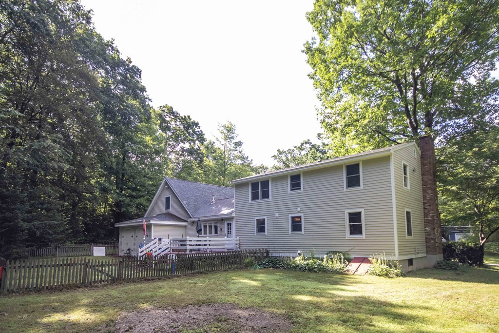 9 Elwood Road Derry, NH 03038 - Photo 4 of 42 a front view of house with yard and trees in the background