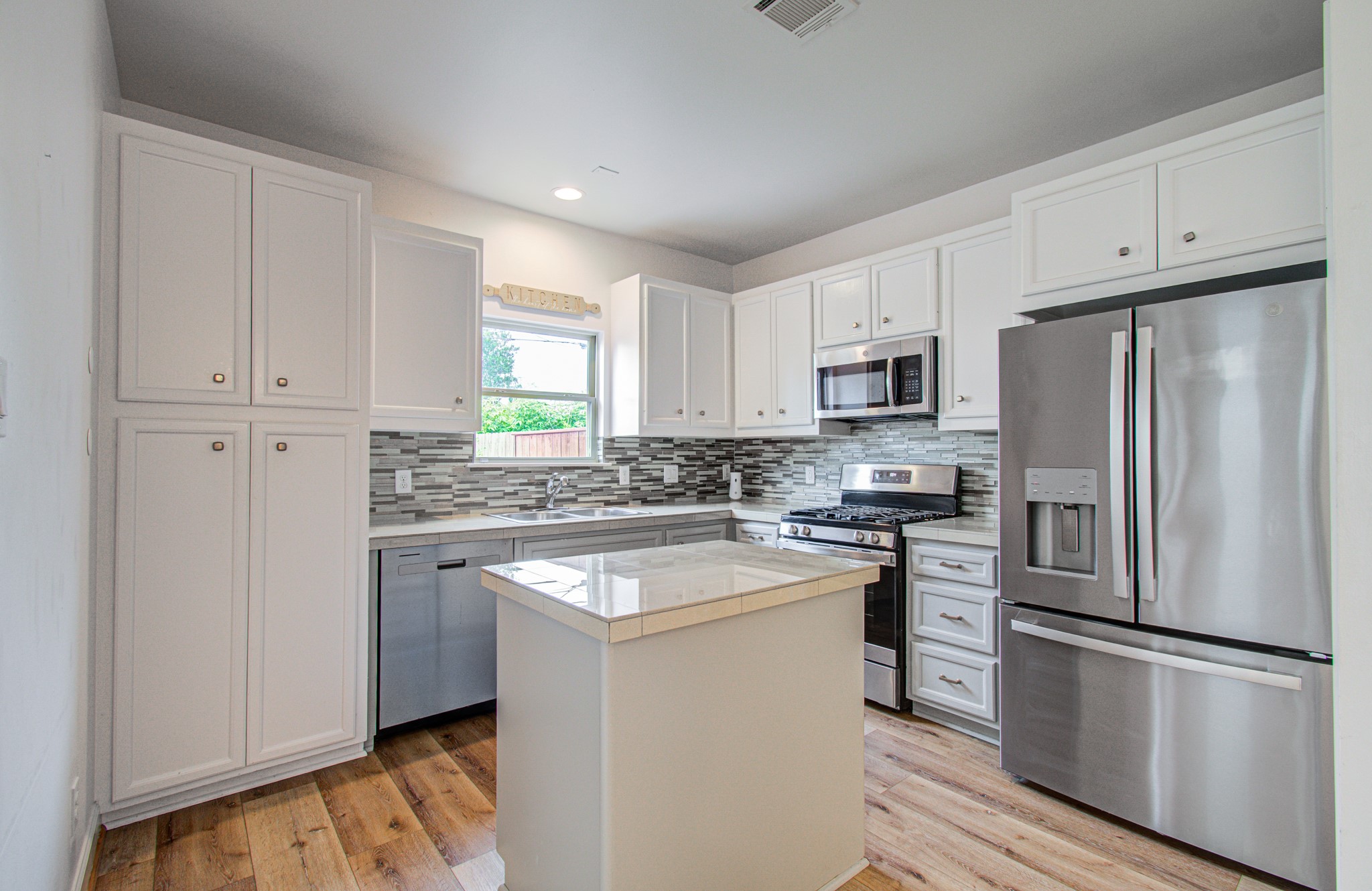 624 East 39th Street Houston, TX 77022 - Photo 14 of 37 a kitchen with cabinets stainless steel appliances and a window