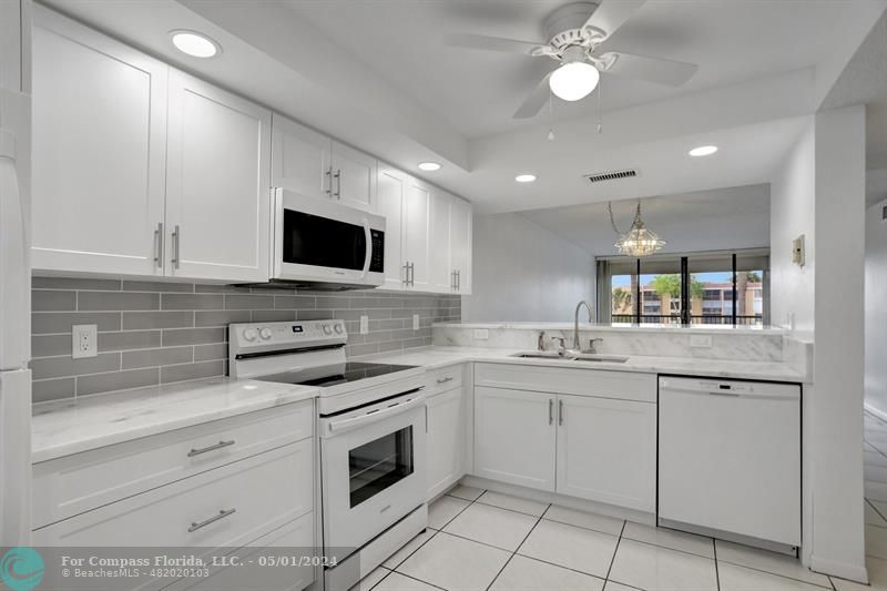 a kitchen with white cabinets appliances and a sink