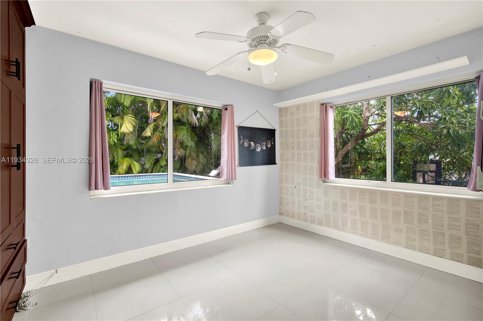 7135 Southwest 19th Terrace Miami, FL 33155 - Photo 31 of 52 an empty room with a window and a ceiling fan